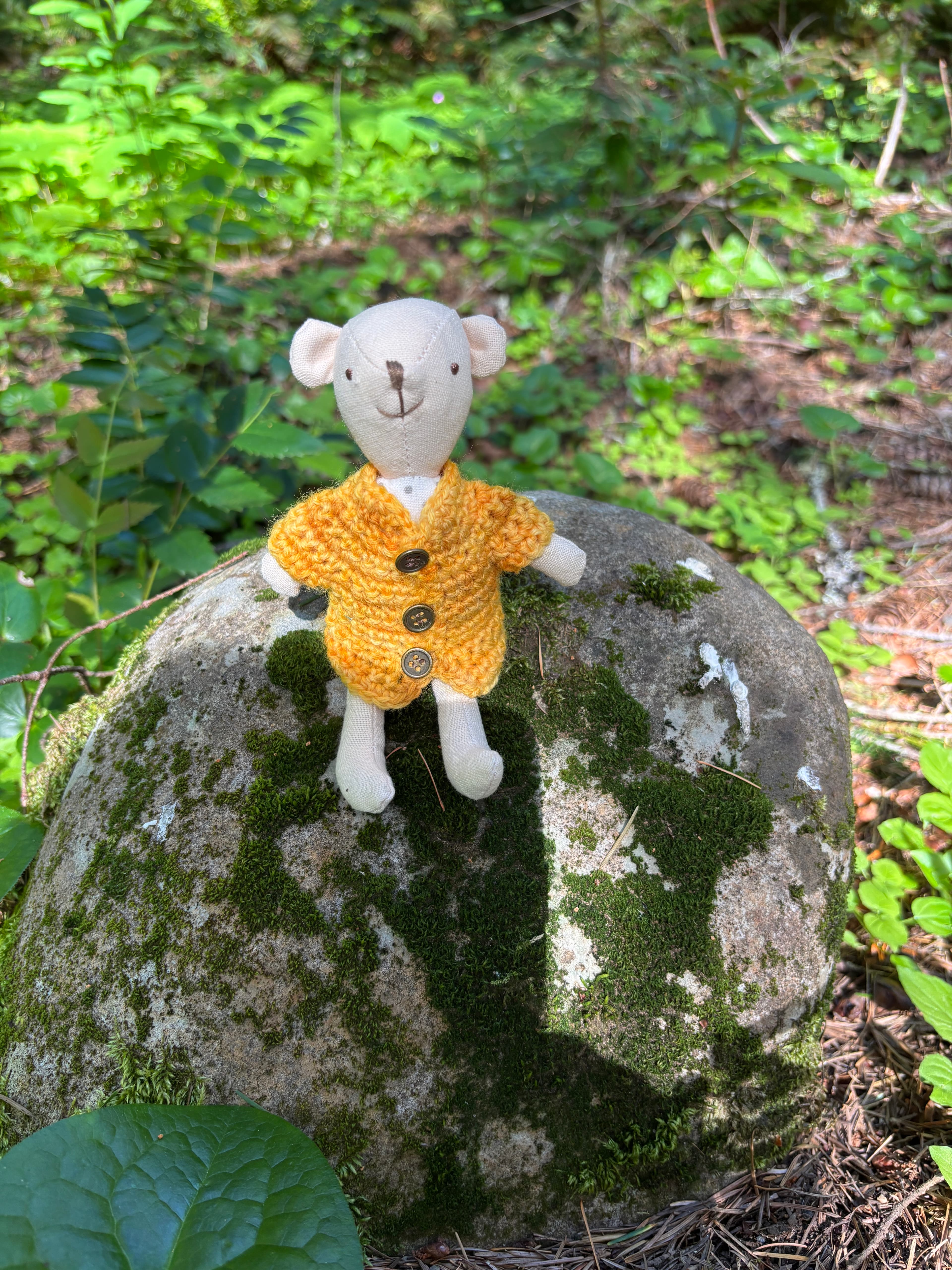 A small cloth doll wearing a soft hand-crochet sweater.