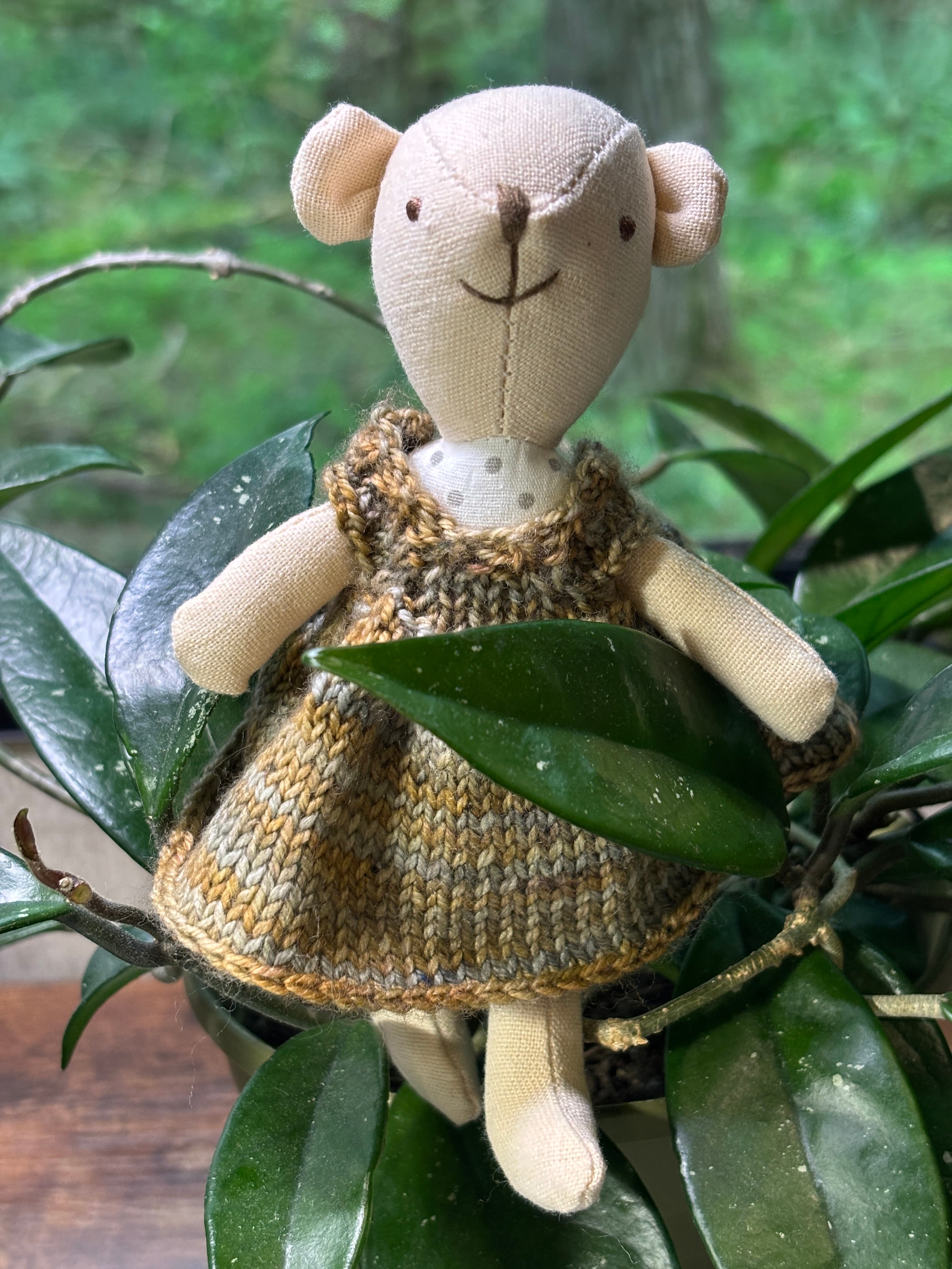 A small cloth doll wearing a knit playful dress.