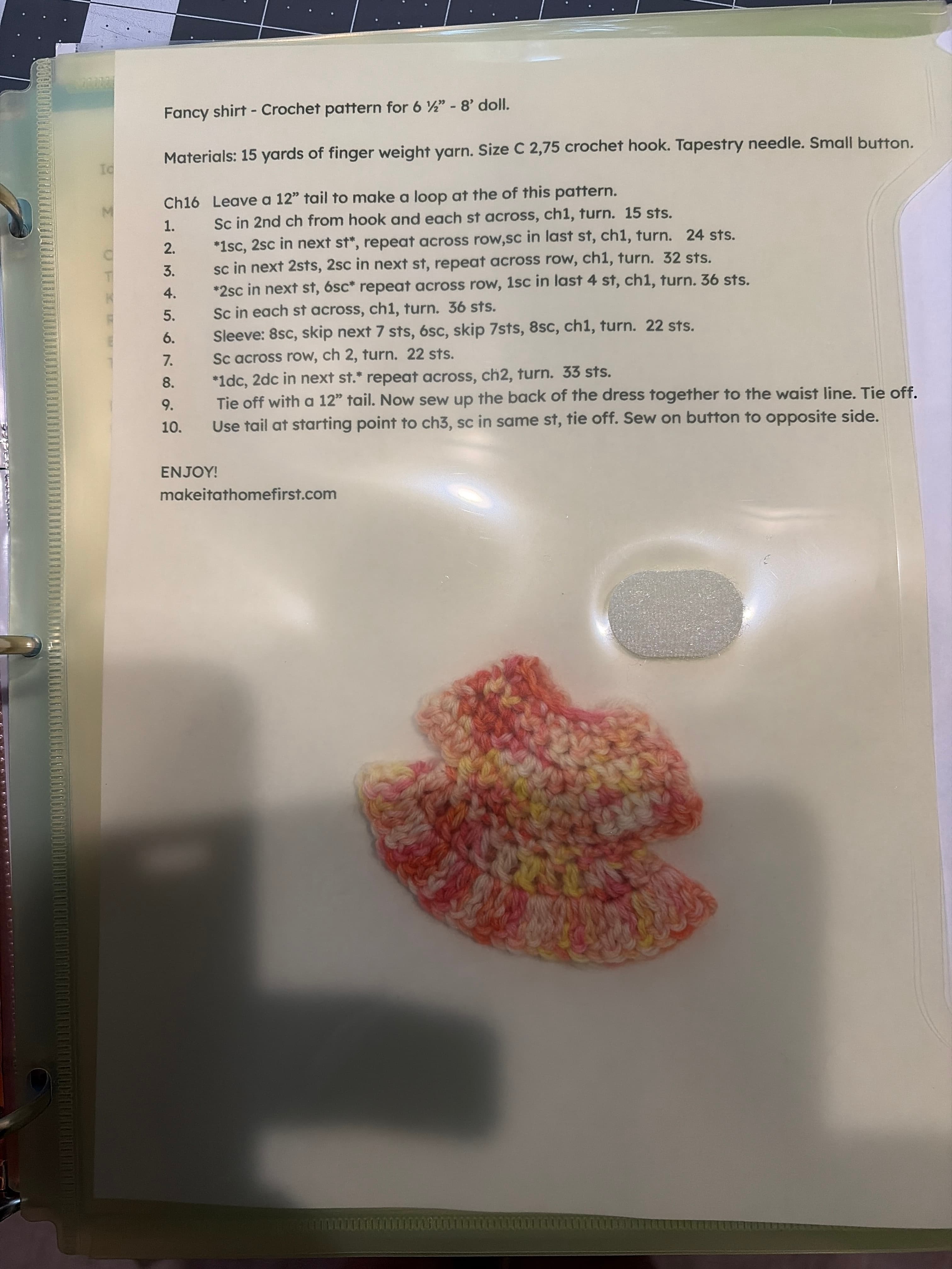 A coral and cream variegated crochet doll shirt on the fancy shirt pattern sheet.